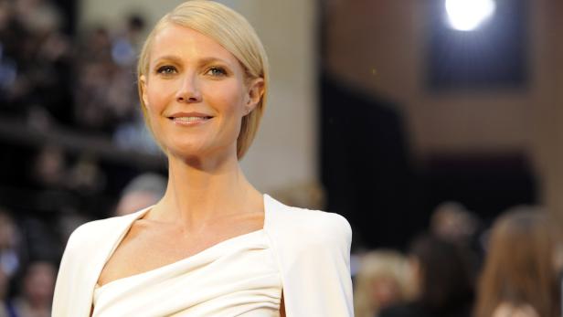 Gwyneth Paltrow lächelt in einem weißen Kleid.