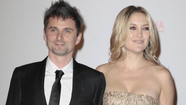 Matt Bellamy und Kate Hudson posieren zusammen auf einem roten Teppich.