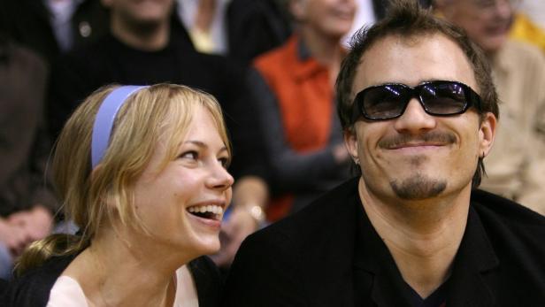 Michelle Williams und Heath Ledger sitzen lächelnd nebeneinander.