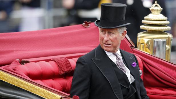 König Charles III. in einer Kutsche mit Zylinder.