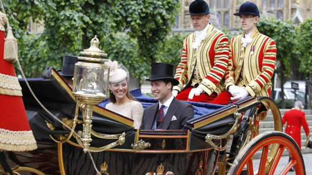 Prinz William und Prinzessin Kate fahren in einer offenen Kutsche.