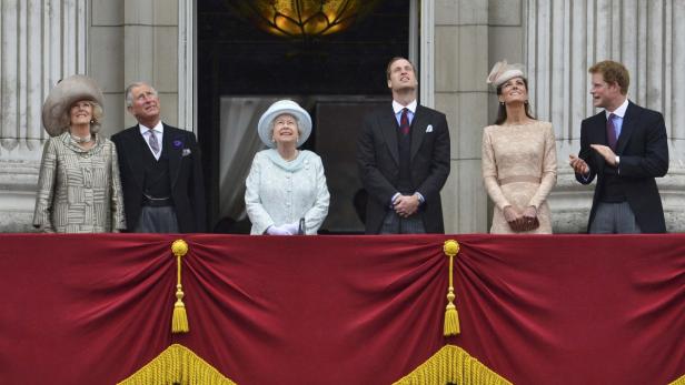 Mitglieder der königlichen Familie auf einem Balkon, die nach oben schauen.
