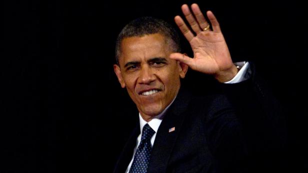 Barack Obama lächelt und winkt in die Kamera.