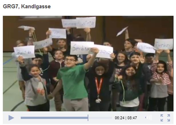 Eine Gruppe von Schülern hält Schilder mit Ländernamen hoch.