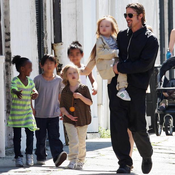 Brad Pitt geht mit seinen Kindern die Straße entlang.