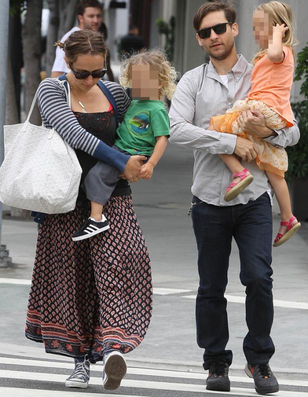 Tobey Maguire und seine Frau tragen ihre Kinder auf einer Straße.