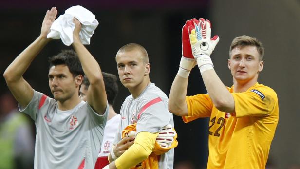 Drei polnische Fußballspieler applaudieren nach einem Spiel.