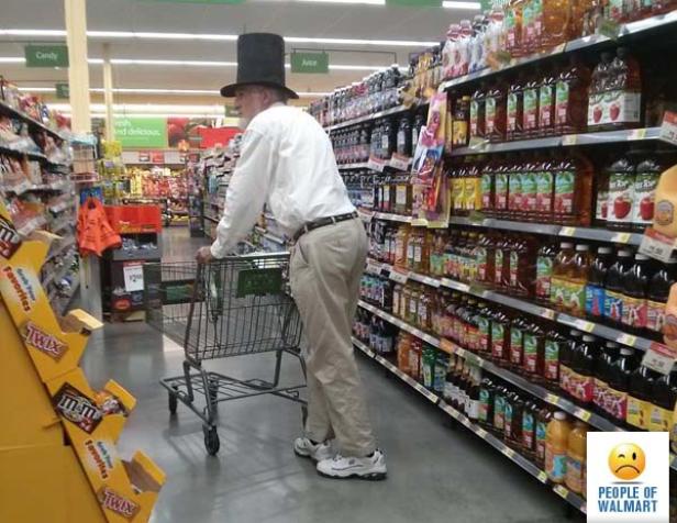 Ein Mann mit Zylinder schiebt einen Einkaufswagen in einem Supermarkt.