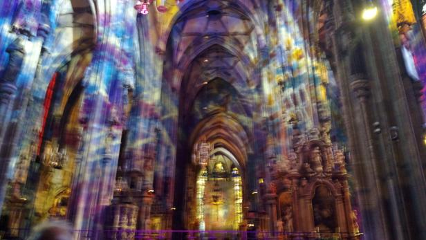 Das Innere einer Kirche ist mit farbigem Licht beleuchtet.