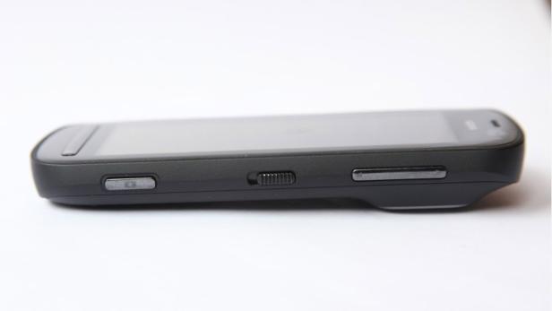 Ein schwarzes Smartphone liegt auf einer weißen Oberfläche.