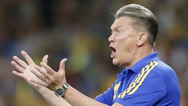 Ein Mann in einem blauen Poloshirt gestikuliert aufgeregt mit beiden Händen.