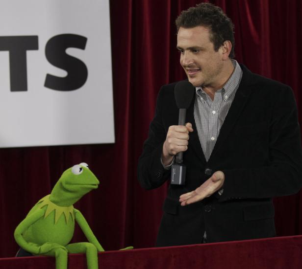 Jason Segel spricht mit Kermit dem Frosch auf einer Bühne.