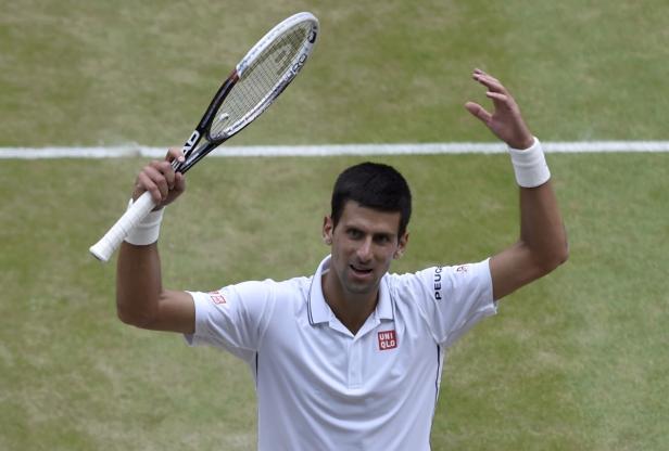 Novak Đoković feiert mit erhobenem Tennisschläger auf dem Platz.