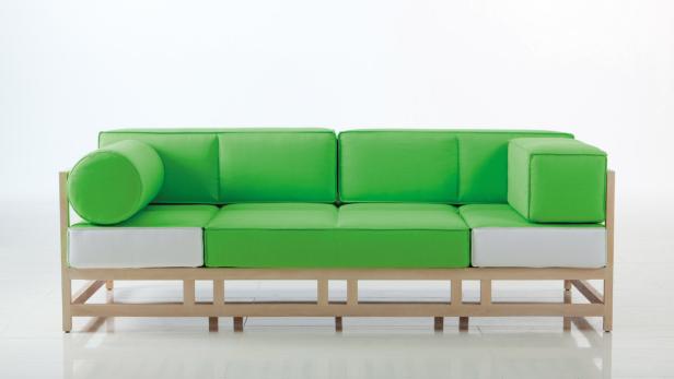 Ein modernes Sofa mit hellgrünen Kissen und einem hellen Holzrahmen.