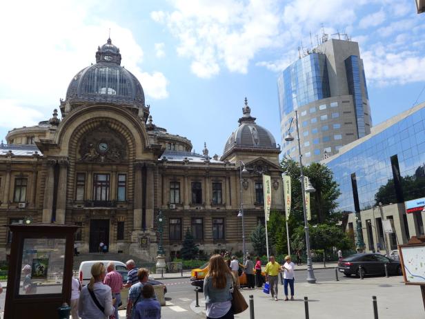 Das historische Gebäude der CEC Bank steht neben einem modernen Bürogebäude in Bukarest.