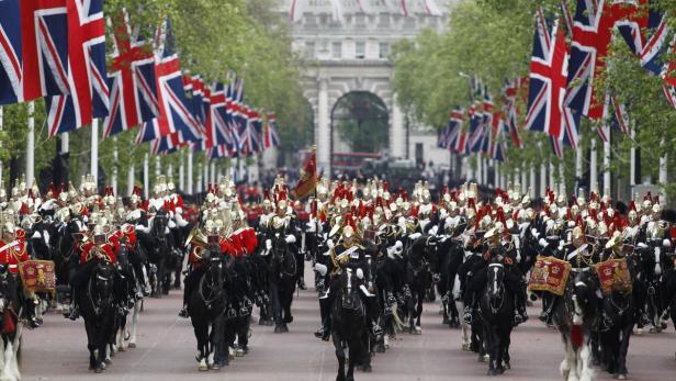 Eine Militärparade mit berittenen Soldaten unter britischen Flaggen in London.