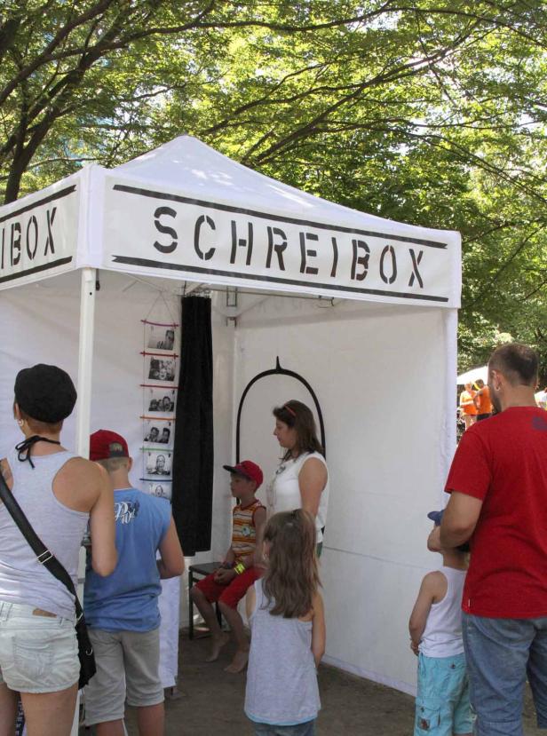 Menschen stehen vor einer „Schreibox“ im Freien.
