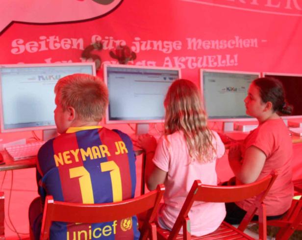 Drei Kinder sitzen vor Computern mit der Aufschrift „Seiten für junge Menschen“.