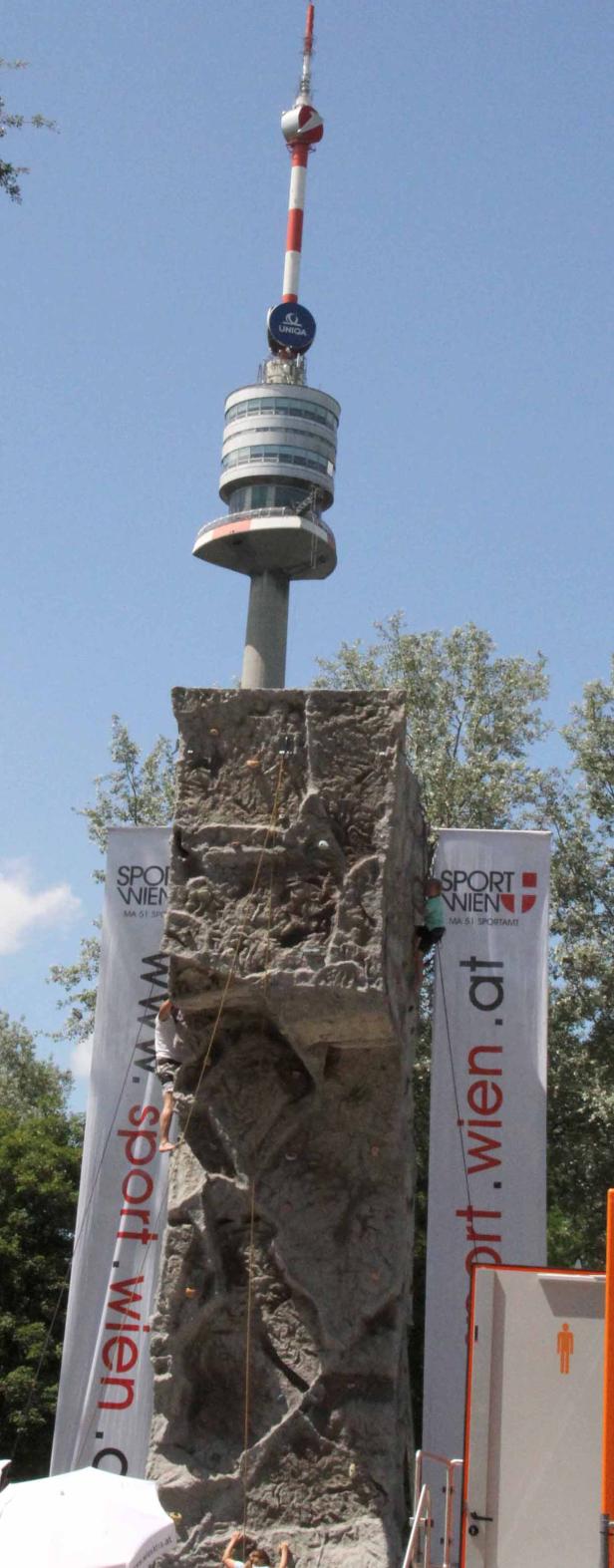 Kletterer an einer künstlichen Kletterwand vor dem Wiener Donauturm.