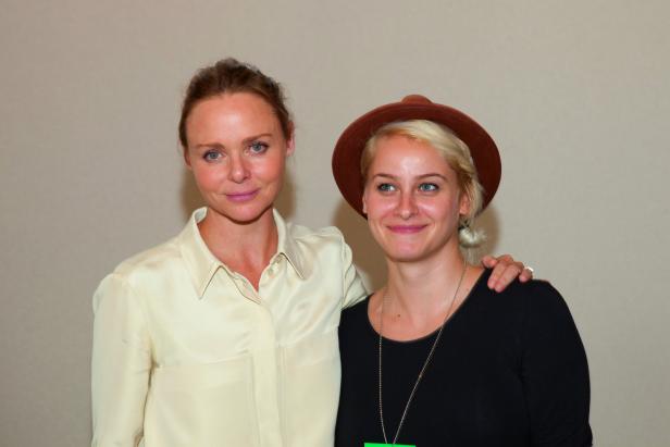 Stella McCartney posiert mit einer Frau mit Hut.
