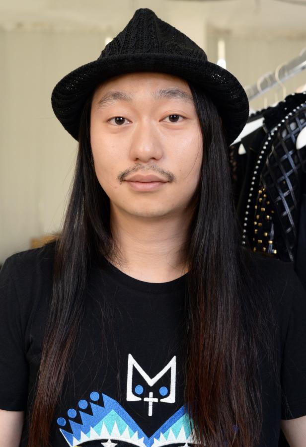 Ein Mann mit Hut und langem, dunklem Haar blickt in die Kamera.