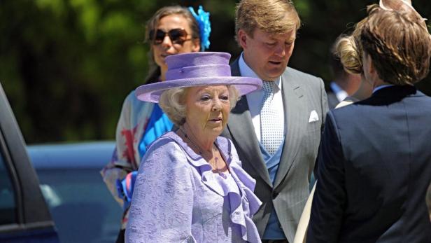 Königin Beatrix der Niederlande mit König Willem-Alexander im Hintergrund.