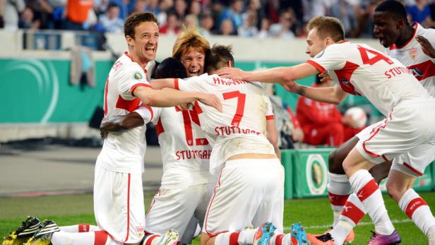 Fußballspieler des VfB Stuttgart feiern gemeinsam auf dem Rasen.