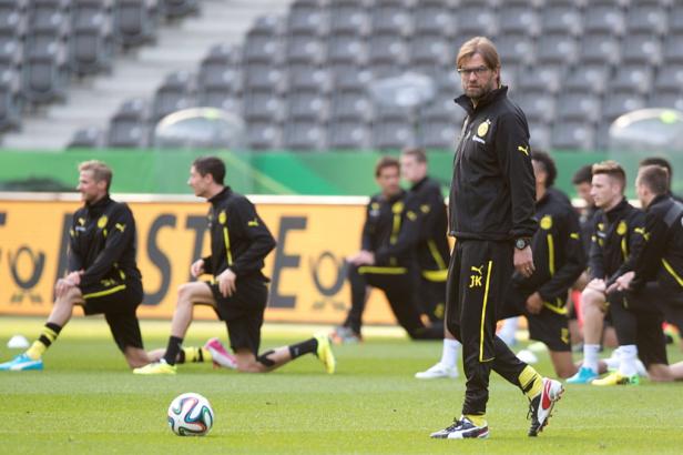 Jürgen Klopp beobachtet, wie sich die Spieler von Borussia Dortmund auf dem Rasen dehnen.