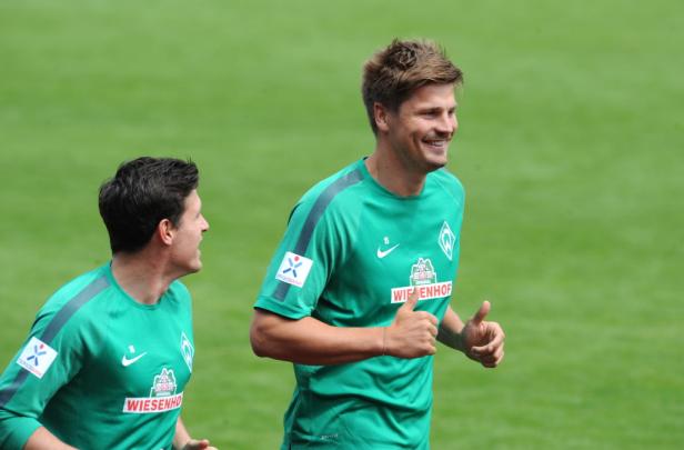 Zwei Fußballspieler von Werder Bremen in grünen Trikots beim Laufen.