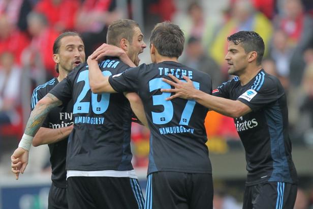 Fußballspieler des Hamburger SV feiern gemeinsam auf dem Spielfeld.