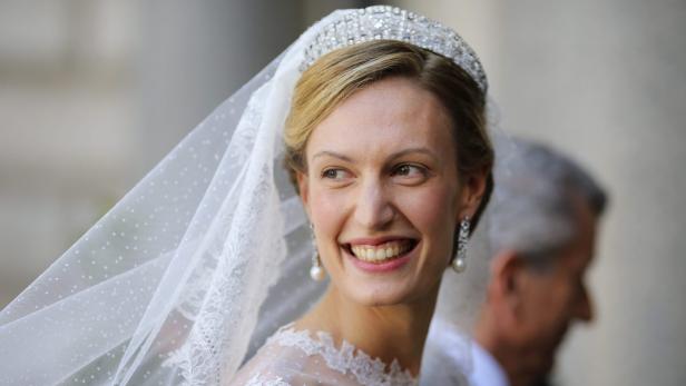 Eine strahlende Braut mit Diadem und Schleier am Hochzeitstag.