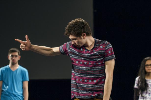 Ein junger Mann deutet mit der Hand in eine Richtung.