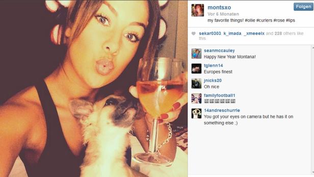Eine Frau macht ein Selfie mit Lockenwicklern, einem Hund und einem Glas Wein.