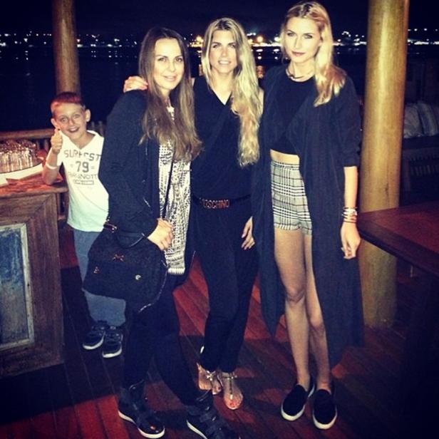 Drei Frauen posieren mit einem Jungen in einem Restaurant für ein Foto.