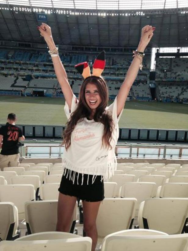 Eine Frau mit Deutschland-Haarreif jubelt auf der Tribüne eines Stadions.