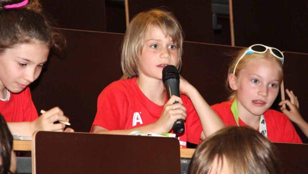 Ein Kind spricht bei einer Veranstaltung in ein Mikrofon.