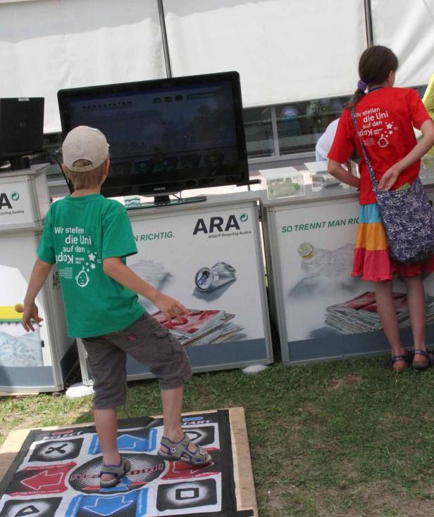 Ein Junge spielt ein Tanzspiel auf einer Matte vor einem Bildschirm.