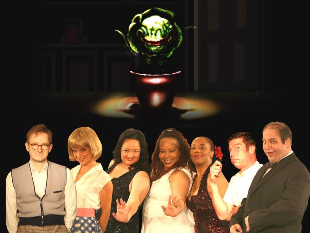 Eine Gruppe von Schauspielern posiert vor einer Pflanze mit einem grinsenden Gesicht in einem Topf.