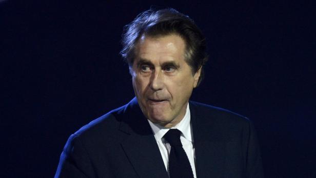 Michel Platini in einem dunklen Anzug mit Krawatte.