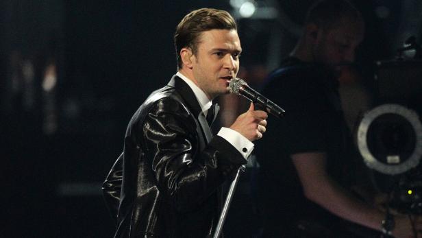 Justin Timberlake singt in einem glänzenden Anzug auf der Bühne.