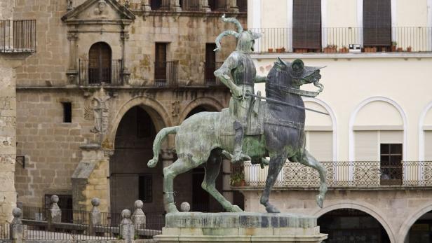 Eine Statue eines Ritters zu Pferde vor historischen Gebäuden.