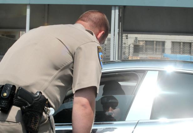 Ein Polizist beugt sich zu einem Auto, um mit dem Fahrer zu sprechen.