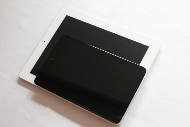 Ein weißes Tablet liegt unter einem kleineren, schwarzen Tablet.