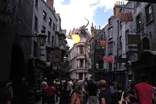 Ein Drache speit Feuer über der Winkelgasse im Themenpark Harry Potter.