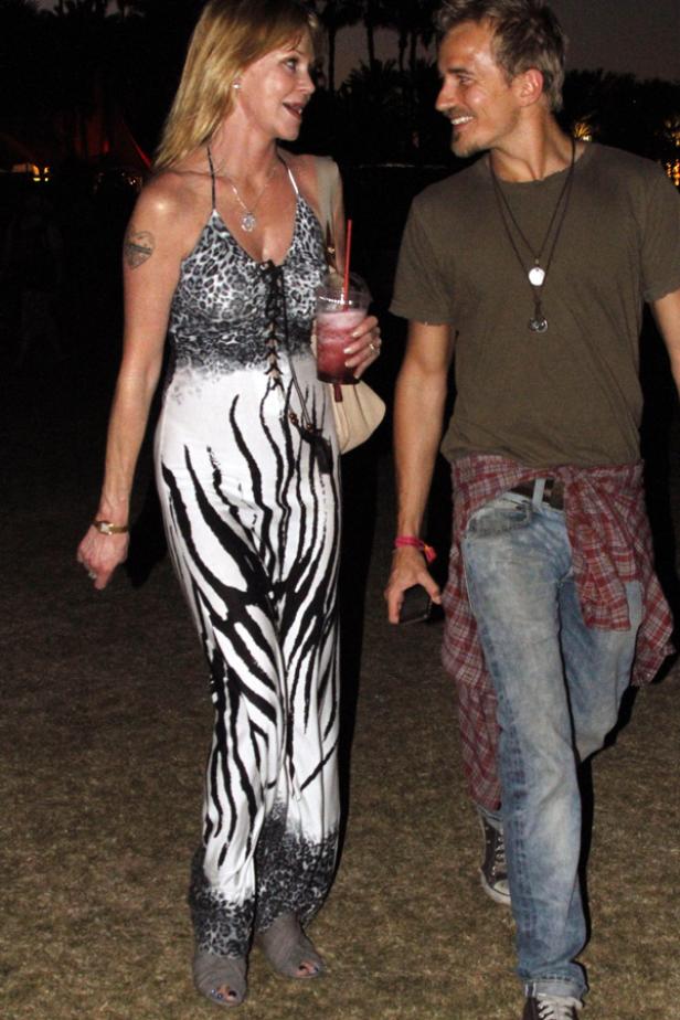 Melanie Griffith und ein Mann gehen zusammen auf einer Veranstaltung.