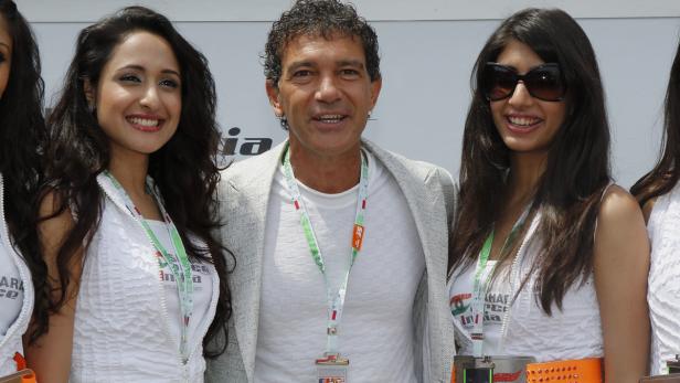 Antonio Banderas posiert mit mehreren jungen Frauen für ein Foto.