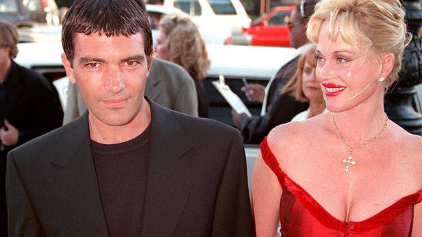 Antonio Banderas und Melanie Griffith posieren auf einem roten Teppich.