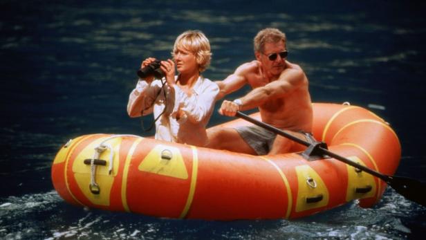 Harrison Ford und Anne Heche in einem Schlauchboot auf dem Wasser.