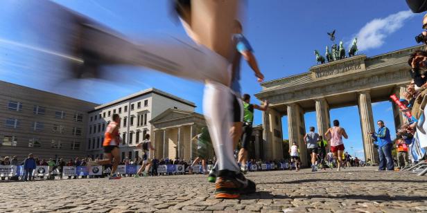 Läufer beim Berlin-Marathon passieren das Brandenburger Tor.