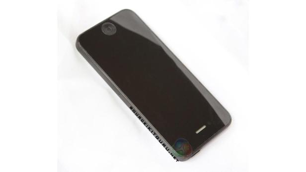 Ein schwarzes Smartphone liegt auf einem weißen Untergrund.